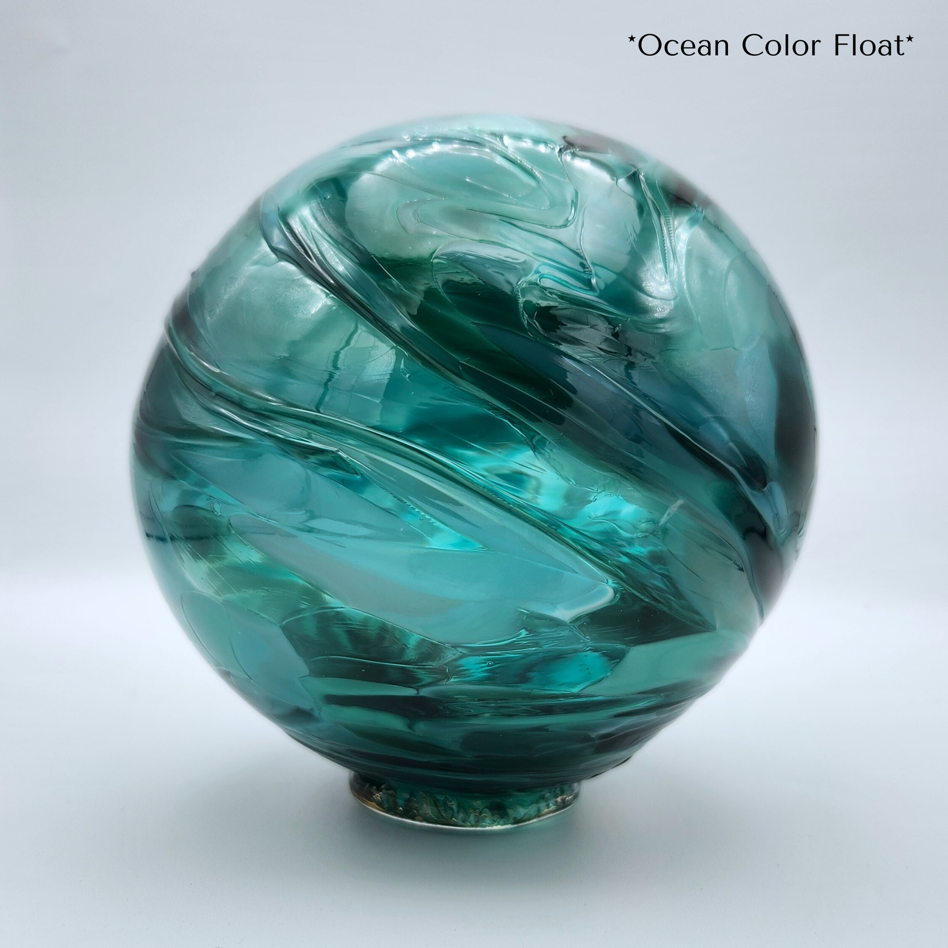 multiple shades of teal blown glass float with glass foot to sit on
