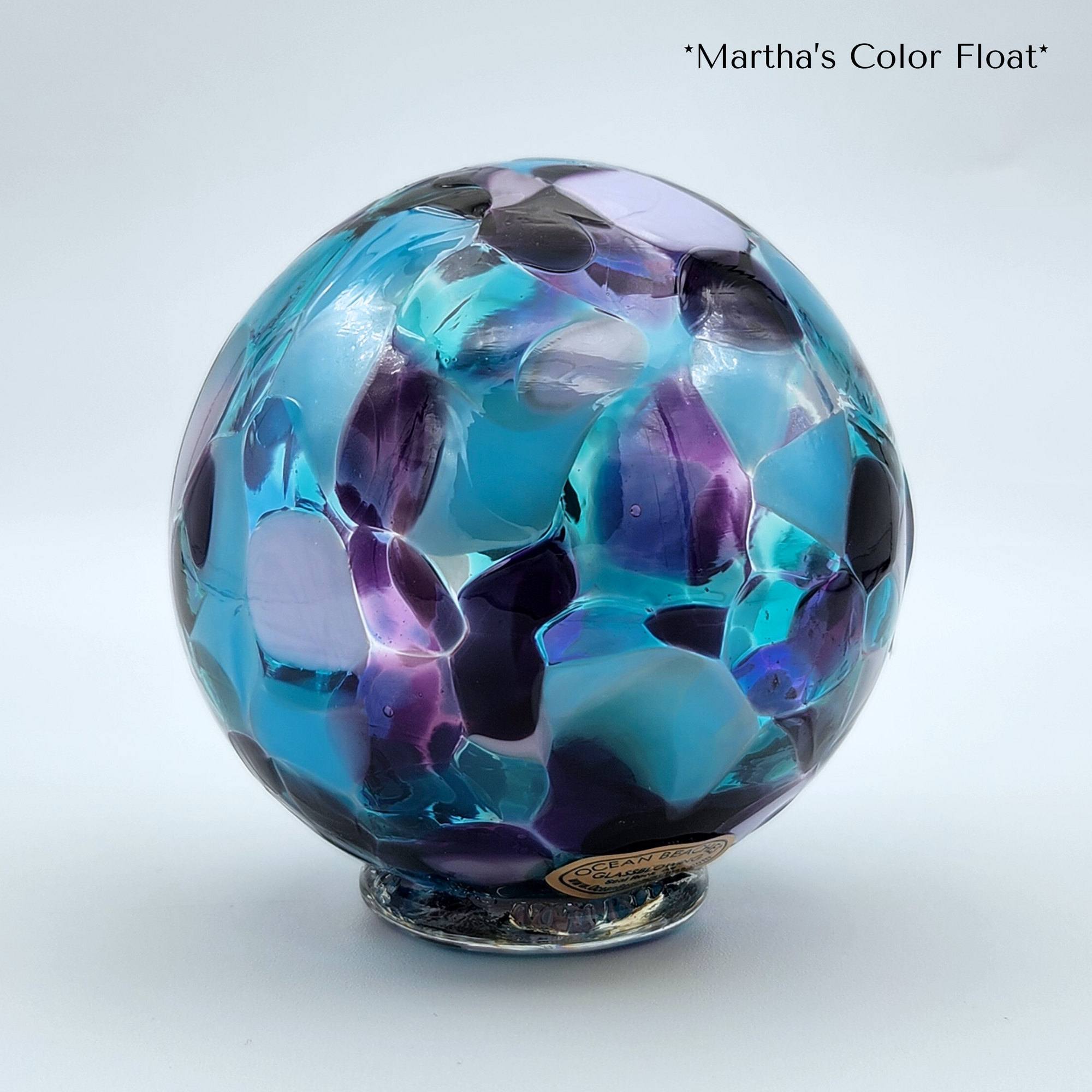 Colorful glass sphere with 'Martha's Color Float' text on a white background