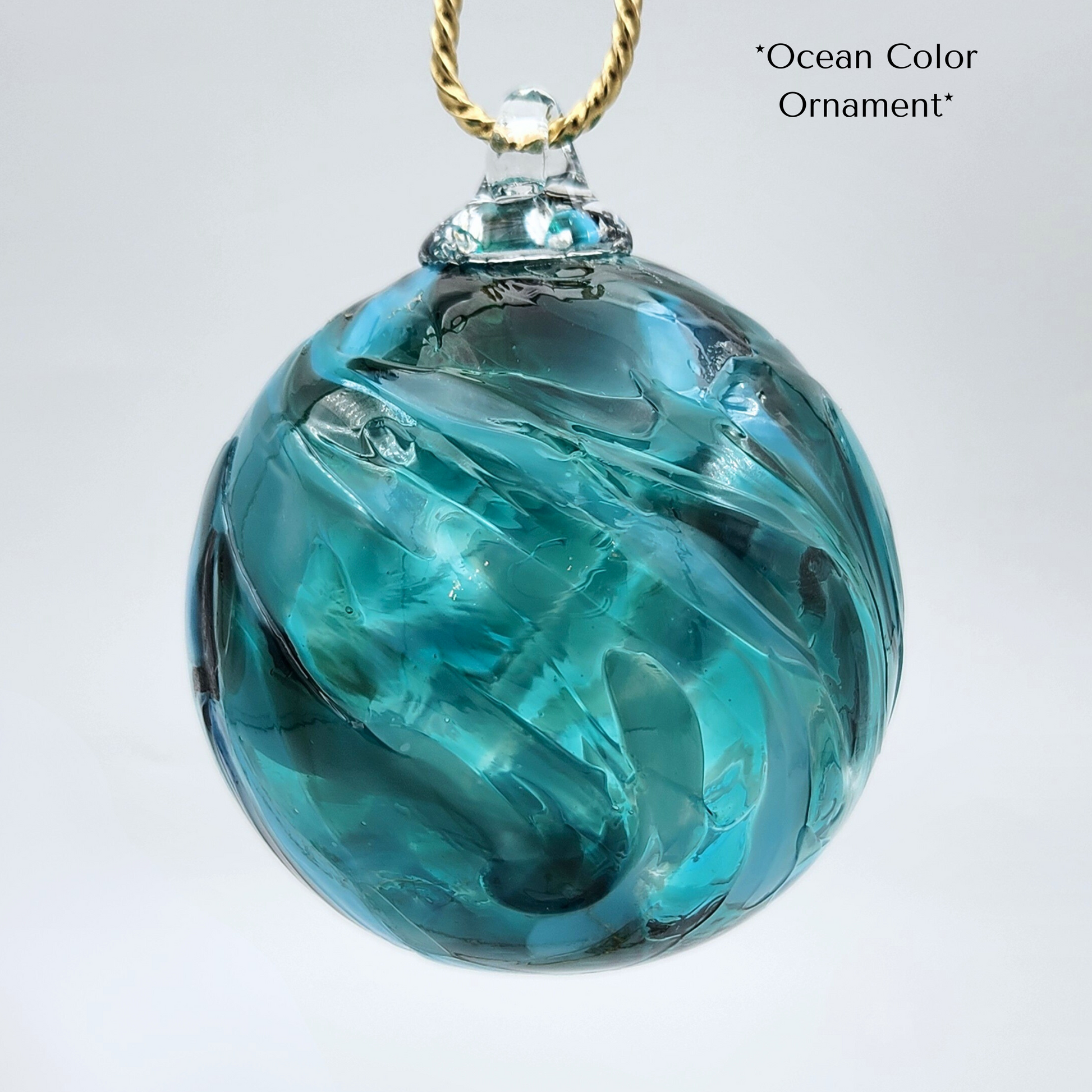 multiple shades of teal glass ornament, has glass hook fused to piece for hanging.